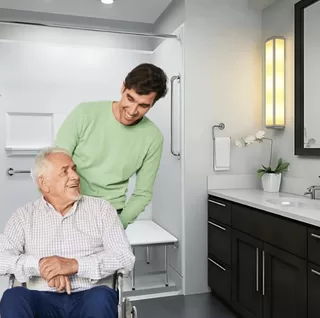 Accessible shower with senior wheelchair user and caregiver